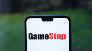 GameStop logo on the smartphone screen and blurred background. GME stock