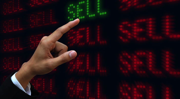 Hand pushing sell. Stocks to sell. Russell 2000 Stocks to Sell