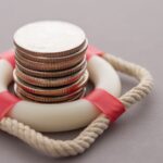 A concept image showing a stack of coins surrounded by a life preserver.