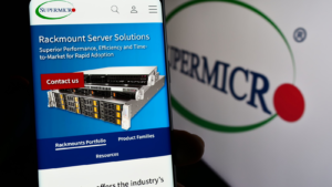 Person holding mobile phone with web page of US company Super Micro Computer Inc. (Supermicro) in front of logo. Focus on center of phone display. Unmodified photo. SMCI stock