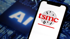 In this photo illustration, the logo of Taiwan Semiconductor Manufacturing Company, TSMC, with AI chip in the background. TSM stock