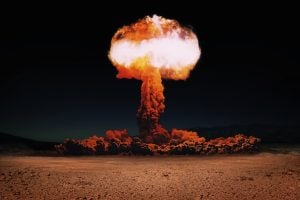 This image shows a large mushroom cloud explosion over an arid desert landscape. The colors range from orange to white, creating a dramatic and intense mood. The photograph evokes themes of power, destruction, and the future. It could be used in projects focused on science, technology, post-apocalyptic events, or abstract concepts.